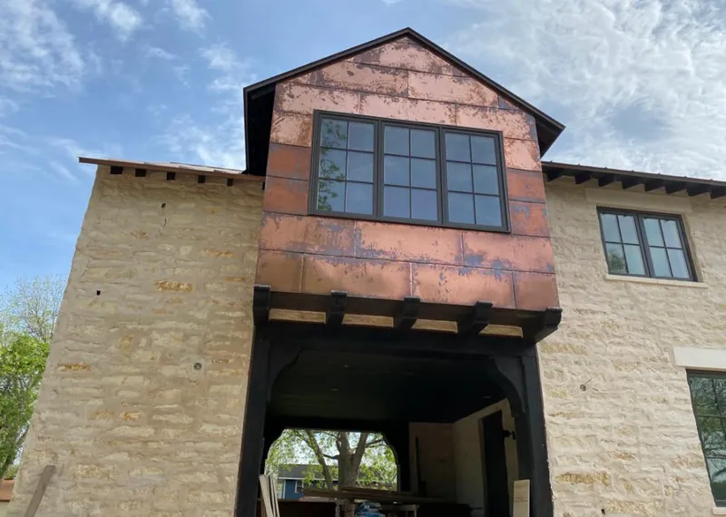 Copper metal panel facade on a stone building for Roof Repair in Arlington