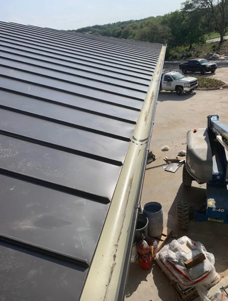 Standing seam panel and gutter detail on a metal roofing jobsite in Arlington